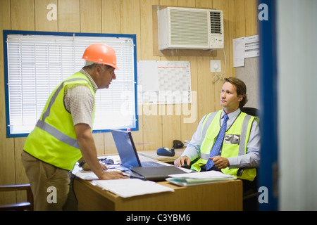 Architekt im Gespräch mit einem Bauarbeiter Stockfoto