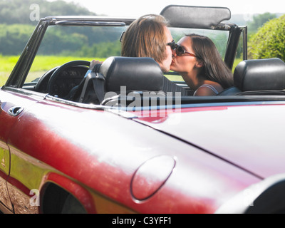 Frisch verheiratetes Paar küssen im Auto Stockfoto