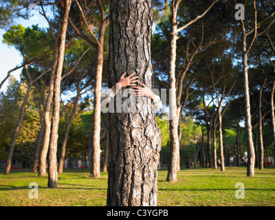Frau umarmt einen Baum Stockfoto