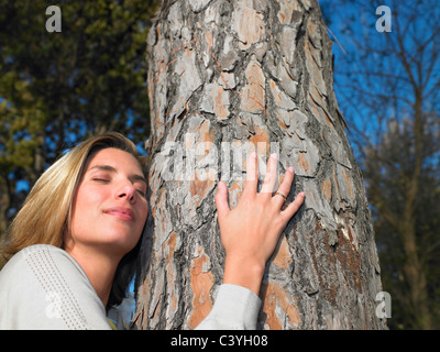 Frau umarmt einen Baum Stockfoto