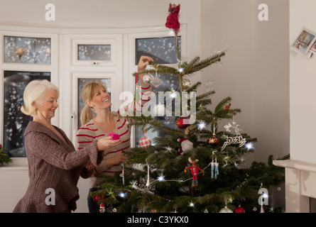 Eine Mutter und Tochter einen Baum schmücken Stockfoto