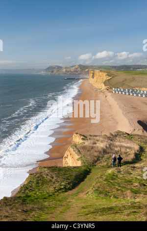 Zwei Wanderer genießen Sie den Blick auf die herrliche Aussicht von den Klippen von Burton Bradstock, Blick in Richtung East Cliff, Dorset Stockfoto