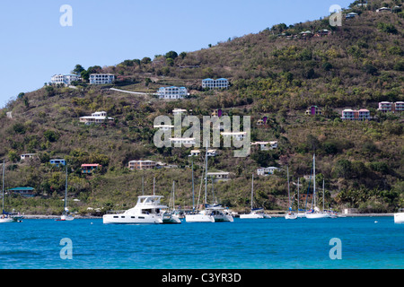 Häusern thront auf dem Hügel über Segelboote vor Anker in Cane Garden Bay auf Tortola, British Virgin Islands Stockfoto