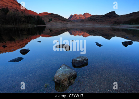 Spätherbst Licht auf den eisigen Rändern eine ruhige Blea Tarn in den Lake District in England Stockfoto