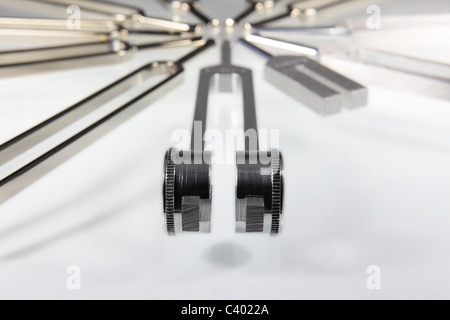 Close-up auf dem Om Stimmgabel und anderen Stimmgabeln können in den Boden zurück. Weißer, reflektierender Oberfläche. Stockfoto