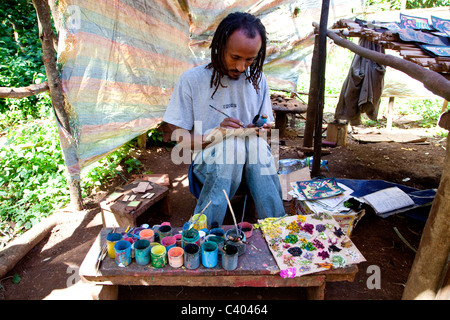 Junger afrikanischer Künstler mit natürlichen Farben, um Souvenirs zu malen, Lake Tana, Äthiopien, Afrika. Schwarzer Mann malt als Hobby und Job Stockfoto