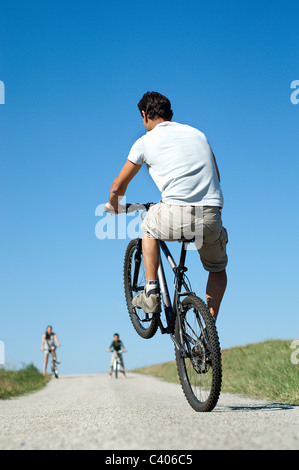 Vater mit der Familie einen Wheelie zu tun Stockfoto