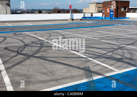 Kautschuk-Reifenspuren auf der Oberfläche von einem Parkplatz leer auf dem Dach. Stockfoto