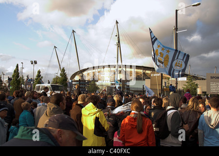 Fans sammeln außerhalb der City of Manchester Stadium, jetzt die Etihad für die Manchester City Cup Parade 2011 Stockfoto