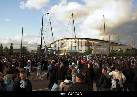 Fans sammeln außerhalb der City of Manchester Stadium, jetzt die Etihad für die Manchester City Cup Parade 2011 Stockfoto