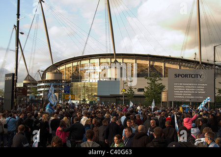 Fans sammeln außerhalb der City of Manchester Stadium, jetzt die Etihad für die Manchester City Cup Parade 2011 Stockfoto