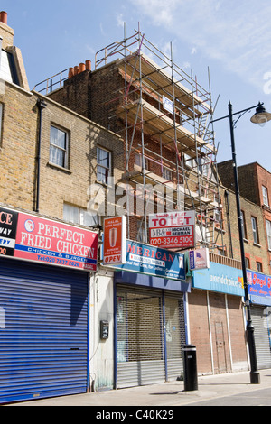 London, Islington, Kapelle Markt, Ladenzeile geschlossenen Fensterläden mit Shop & Wohnung zu vermieten Zeichen & Gerüste auf einem Gerät Stockfoto