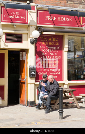 London, Islington, Kapelle Markt, The Alma frei Haus traditionelle Kneipe oder Bar mit zwei Männer rauchen draußen sitzen Stockfoto