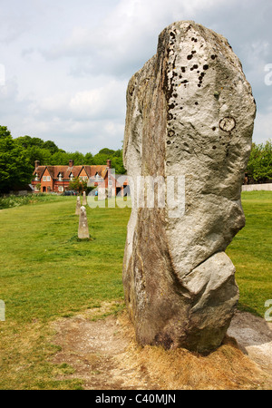 Massive Sarsen Monolith in der äußeren Steinkreis von Avebury in Wiltshire mit einem Haus im Dorf jenseits Stockfoto