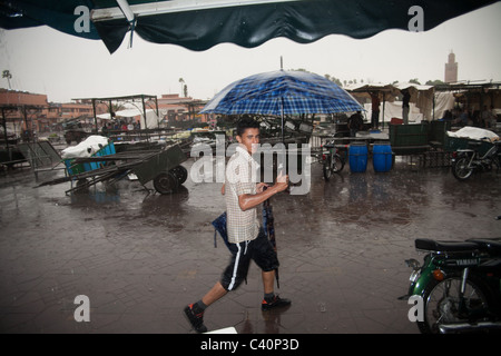 Junge mit einem Regenschirm Djema al Fna an einem sehr regnerischen Tag Stockfoto