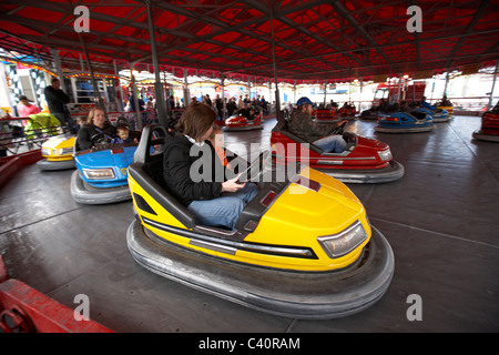 Mutter fahren junge Tochter in eine Stoßstange Autoscooter auf eine Kirmes im Vereinigten Königreich Stockfoto