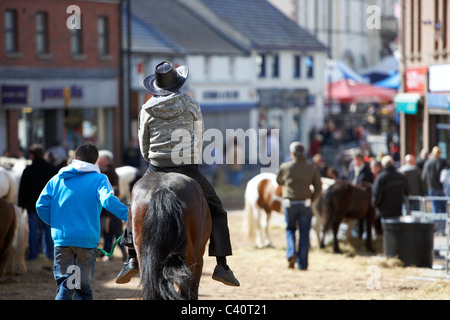 Mann in Cowboy-Hut Reitpferd Hauptstraße in Hennef kann fair County Antrim-Nordirland Stockfoto