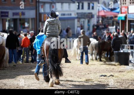 Mann in Cowboy-Hut Reitpferd Hauptstraße in Hennef kann fair County Antrim-Nordirland Stockfoto