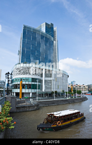 Touristenboot auf den Singapore River in der Nähe von Clarke Quay mit South Bank Gehweg und Geschäften der Republik Singapur Stockfoto