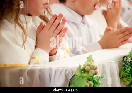 Kinder akzeptieren die erste Heilige Kommunion Stockfoto