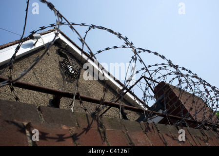 Spulen von Stacheldraht an einer Wand Stockfoto