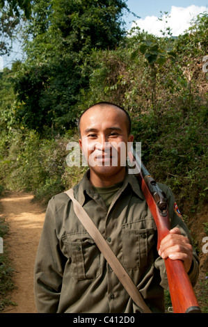 Jäger mit Gewehr über der Schulter auf der Dschungel-Strecke in Nord-Ost-Laos Stockfoto