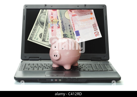 Banknoten aus Laptop und Sparschwein auf weißem Hintergrund - Internet Handel am forex Stockfoto