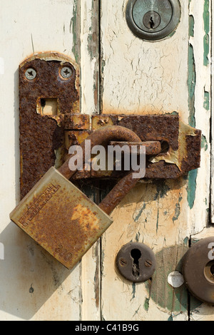 Alte rostige Vorhängeschloß an einer Tür hautnah. Stockfoto