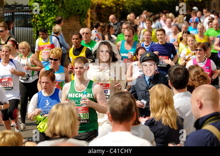 Läufer nehmen an den Virgin London Marathon 2011 mit Läufern das Tragen der Maske von Prinz William und Catherine im Wedding Dress Stockfoto