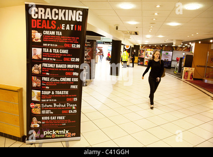 Eine Frau zu Fuß vorbei an der Welcome Break Café-Schild in die mimbar Autobahnraststätten, Autobahn M4, Wiltshire, UK Stockfoto