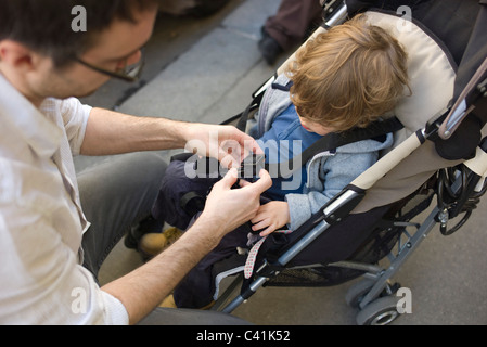 Vater strammer Kleinkind Jungen in Kinderwagen Stockfoto