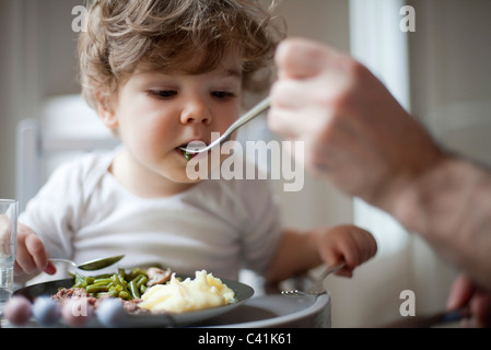 Kleinkind-junge grüne Bohnen gefüttert werden abgeschnitten Stockfoto