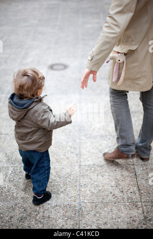 Vater für Kind die Hand auf Bürgersteig, beschnitten zu erreichen Stockfoto
