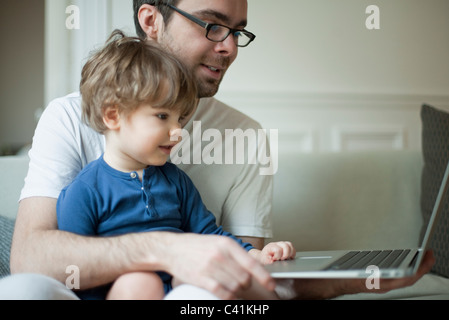 Kleinkind-junge mit Laptop-Computer mit Vater Stockfoto