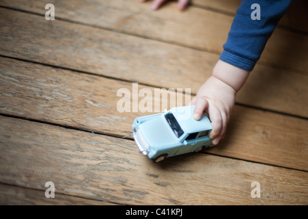 Kind an der Hand halten Spielzeugauto Stockfoto