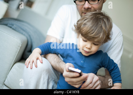 Kleinkind Vater des jungen beobachten mit Handy Stockfoto