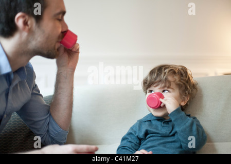 Vater und Kind Sohn Tat zu trinken Tee mit Spielzeug Teetassen Stockfoto