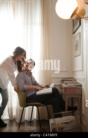 Paar sprechen beim Magazin zusammen betrachten Stockfoto
