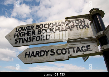 Eine alte hölzerne Wegweiser den Weg zu Thomas Hardy's Cottage, Higher Bockhampton und stinsford Church, wo er begraben liegt, Dorset, England. Stockfoto