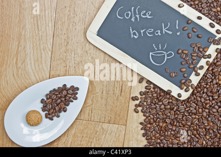 Kaffeebohnen mit Cookies auf einem weißen Teller und ein Brett Stockfoto