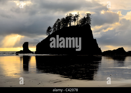 Silhouette des Sea Stacks am zweiten Strand. Eine Welle von Licht bricht durch die Wolken. Stockfoto