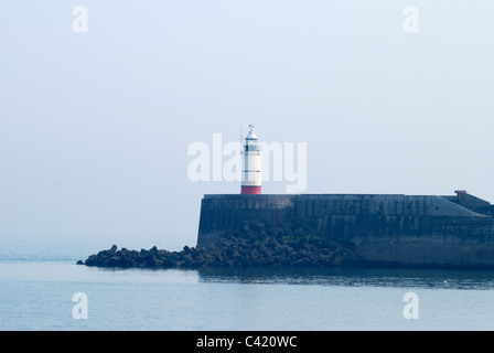 Leuchtturm an der Hafenmauer in Newhaven in East Sussex. England. Nebligen Wetter und ruhige See. Stockfoto