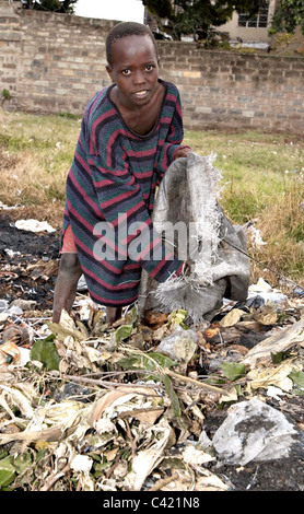 Ein 14 Jahre alter Junge Blick durch den Müll auf einer Müllkippe in Nairobi, Kenia, Afrika, auf der Suche nach Nahrung und Gegenstände zu verkaufen. Stockfoto