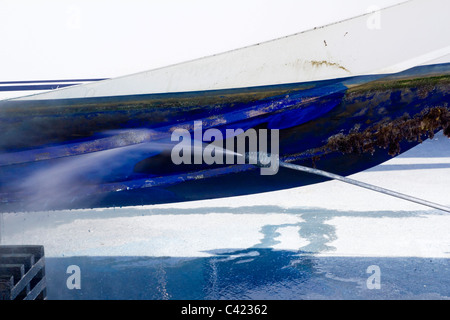 blaue Bootsrumpf Reinigung Druck Waschmaschine Seepocken Antifouling und Algen Stockfoto