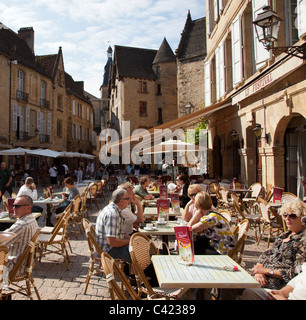 Leute sitzen an Tischen im Freien im zentralen Quadrat Sarlat la Caneda Dordogne Frankreich Stockfoto