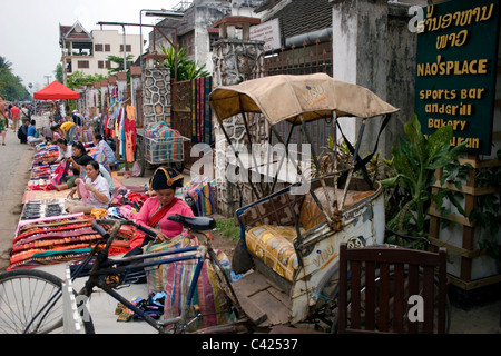 Leute verkaufen waren auf einem Bürgersteig auf einem belebten Straße Markt in kommunistische Laos. Stockfoto