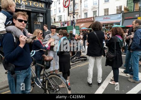 Ein Straßenmusikant inmitten von Menschenmassen an der Ecke von der Herzog von Wellington Pub, Portobello Road, Notting Hill, London Engla Straßenmusik Stockfoto