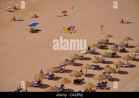 Reihen von Strohschirmen, Praia de Peneco, Albufeira, Algarve-Region, Portugal Stockfoto