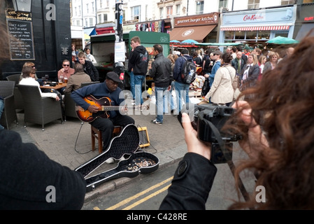 Ein schwarzer Blues Straßenmusiker Straßenmusik Gitarre spielen in Portobello Road Strassenmarkt, Notting Hill, London KATHY DEWITT Stockfoto