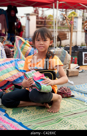 Junge Mädchen mit ihrem Handwerk in Luang Prabang die alte königliche Hauptstadt von Laos zu vermarkten Stockfoto